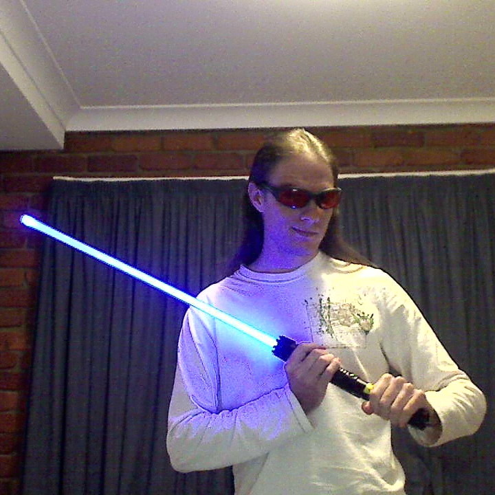 Mike Ando aka riumplus aka RIUM+ holding a blue laser-based lightsaber